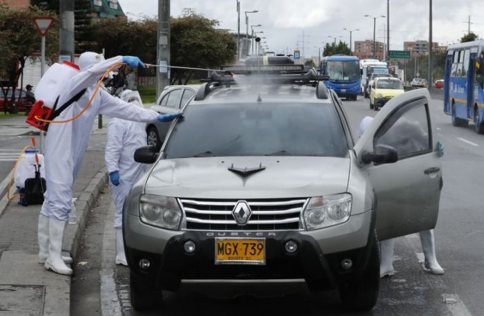 Covid-19: Por falta de empleo ahora desinfectan vehículos en semáforos de Bogotá
